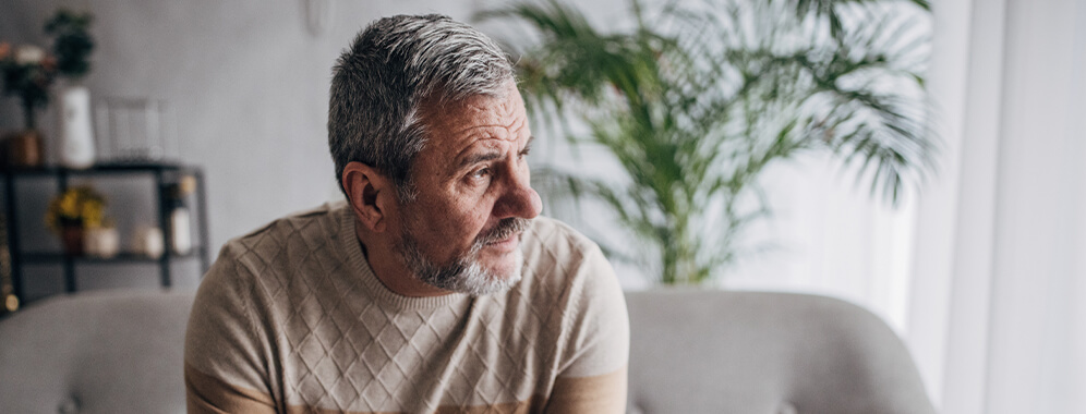 Ein Mann blickt nachdenklich zur Seite.