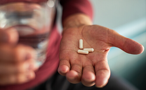 Eine Hand hält einige Pillen. 