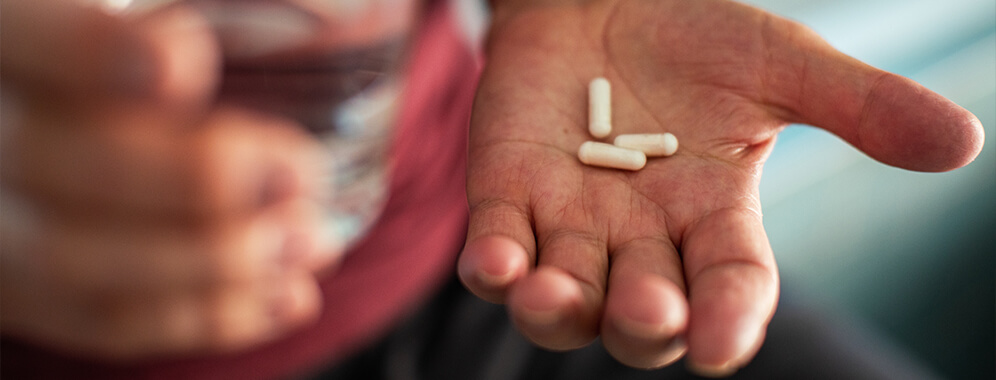 Eine Hand hält einige Pillen.