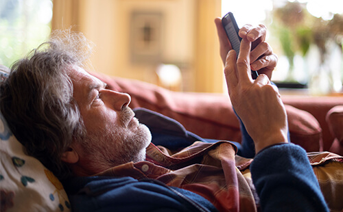 Ein Mann liest etwas auf dem Handy. 