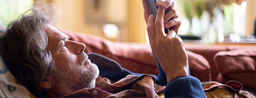 Ein Mann liest etwas auf dem Handy. 