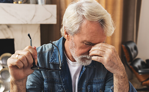 Ein Mann fast sich nachdenklich ins Gesicht. 
