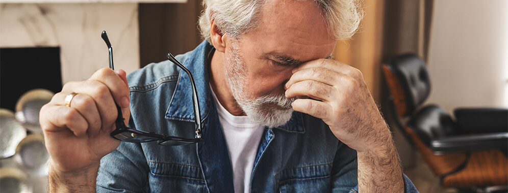 Ein Mann fast sich nachdenklich ins Gesicht. 
