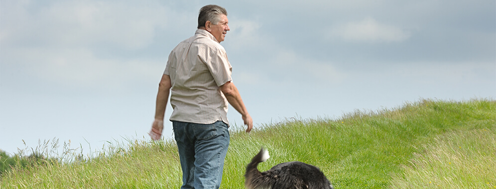 Ein Mann beim Spaziergang mit seinem Hund. 