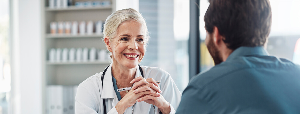 Ein Mann spricht mit einer Ärztin. 