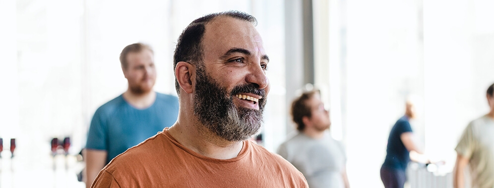 Man sieht einen fröhlichen kräftigen Mann. 