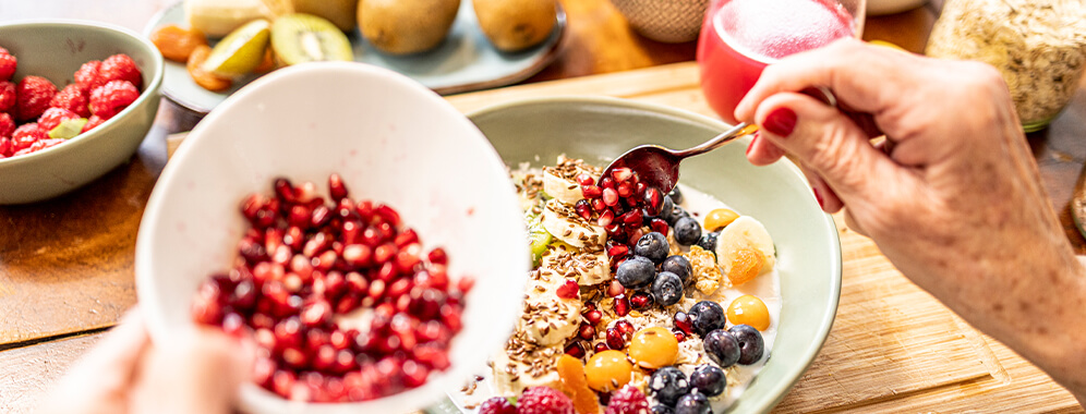 Man sieht ein gesundes Müsli mit viel Obst, Haferkleie und Joghurt.