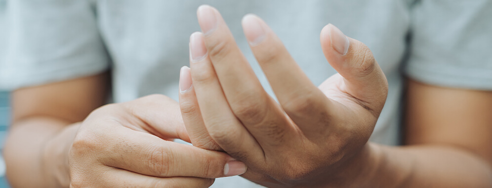 Eine Person hält sich die Hände.