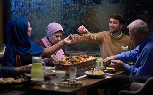 Eine muslimische Familie sitzt am Tisch und isst.