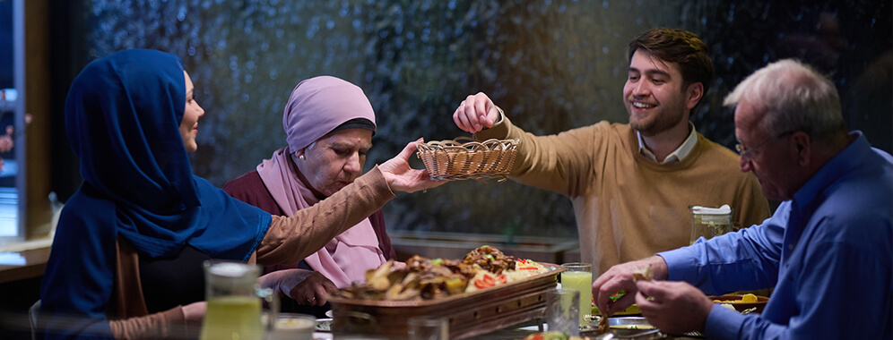 Eine muslimische Familie sitzt am Tisch und isst.