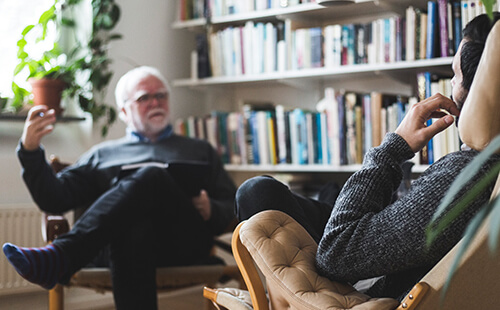 Man sieht eine Gesprächssituation beim Psychologen oder Psychotherapeuten.