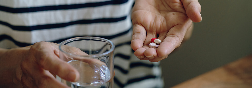 Eine Hand hält einige Pillen. 