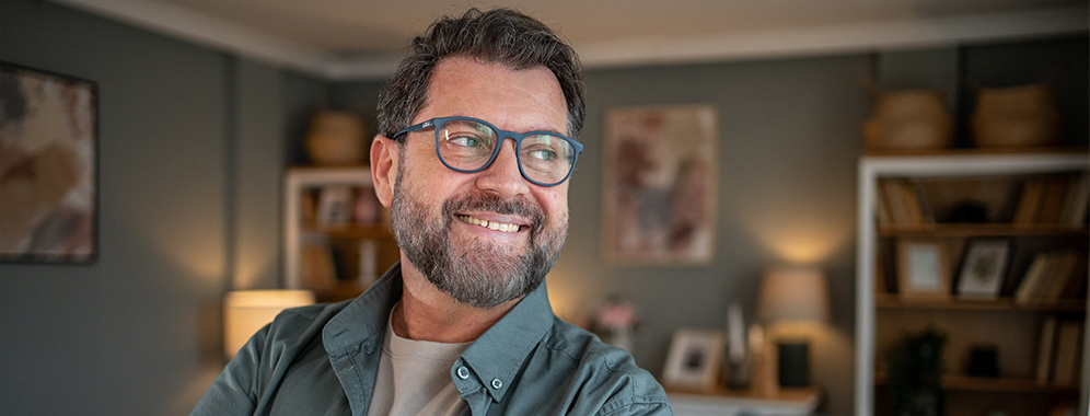 Ein etwas kräftigerer Mann mit Diabetes lächelt in die Kamera.