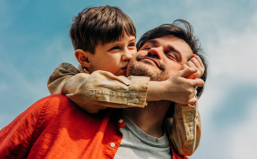 Ein Sohn küsst seinen Vater.