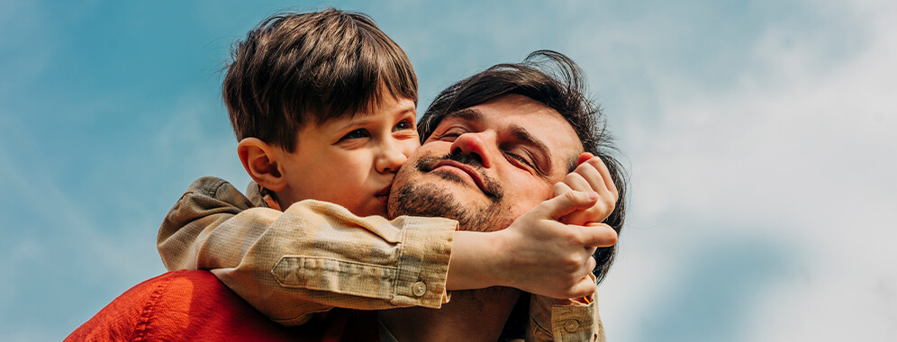 Ein Sohn küsst seinen Vater.