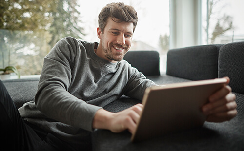 Ein Mann liest etwas auf dem Tablet.