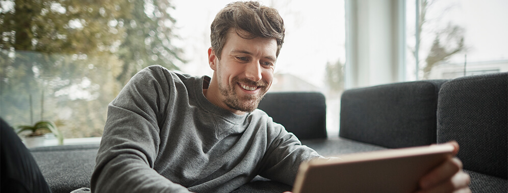 Ein Mann liest etwas auf dem Tablet.