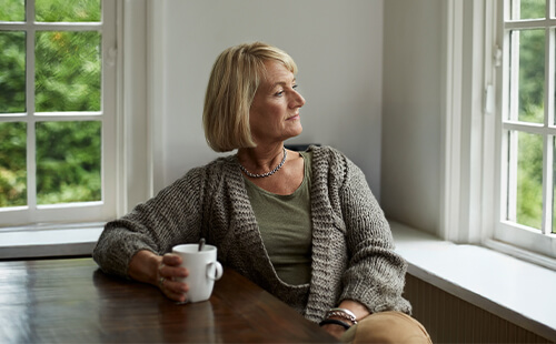 Frau schaut aus dem Fenster. 