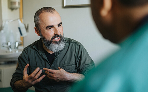 Ein Mann liest nachdenklich etwas auf dem Handy.