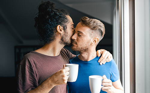 Ein Mann küsst seinen Partner auf die Stirn.