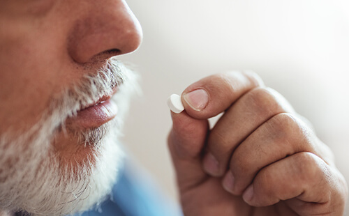 Ein Mann nimmt eine Tablette ein.