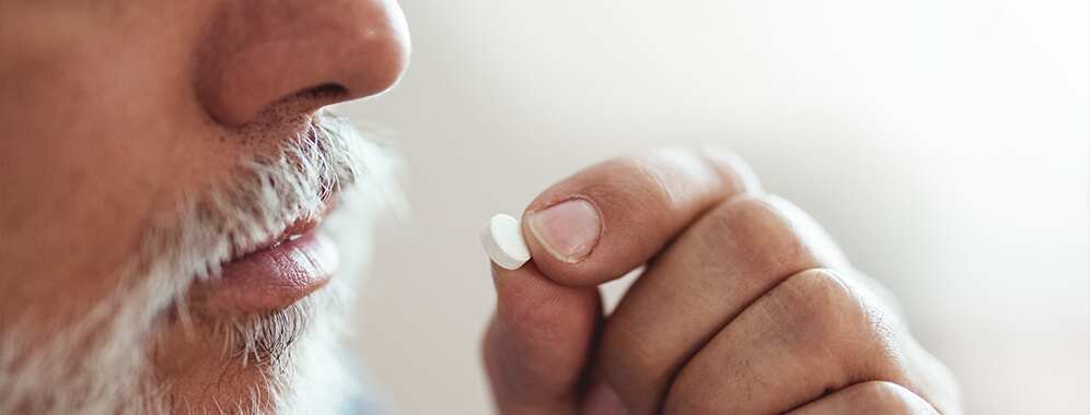 Ein Mann nimmt eine Tablette ein.