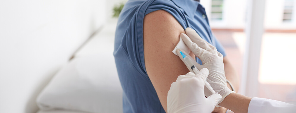 Man sieht eine Impfung in den Oberarm. 