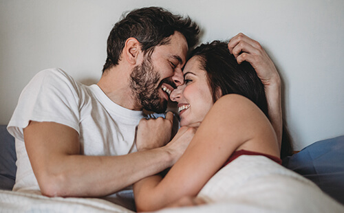 Ein Pärchen umarmt sich lächelnd.