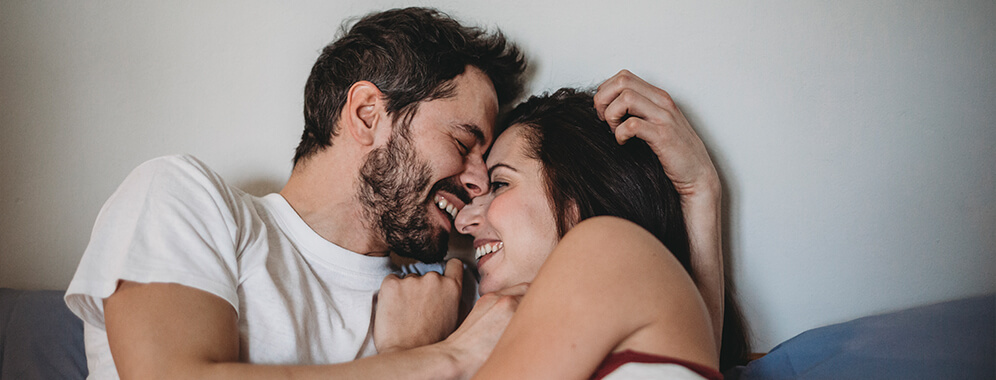 Ein Pärchen umarmt sich lachend. 