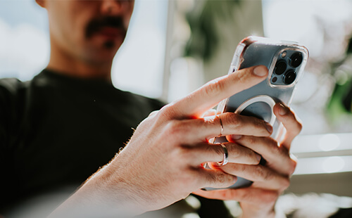 Ein Mann tippt auf seinem Handy.