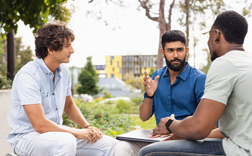Drei Männer unterhalten sich.