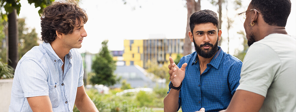 Drei Männer unterhalten sich. 