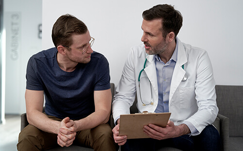 Ein Mann spricht mit einem Arzt.