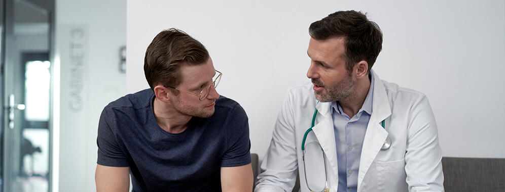 Ein Mann spricht mit einem Arzt.