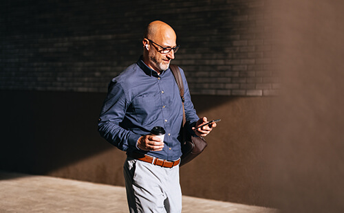 Ein Mann liest etwas an seinem Handy.