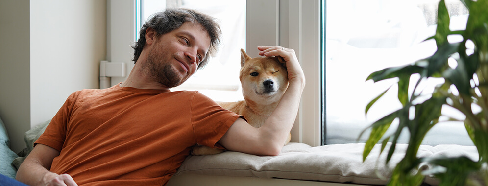 Ein Mann streichelt einen Hund. 