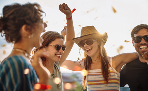 Junge Leue feiern draußen fröhlich.