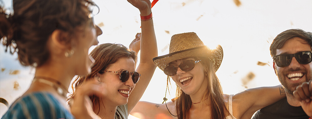 Junge Leute feiern draußen fröhlich. 