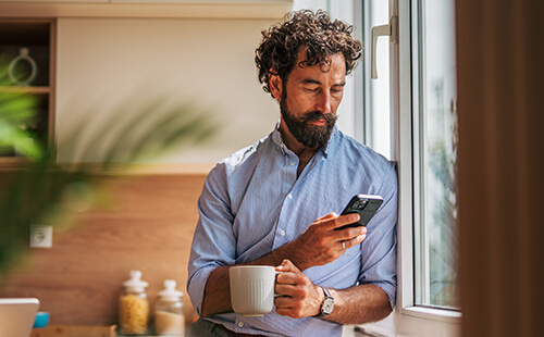 Ein Mann liest etwas am Handy.