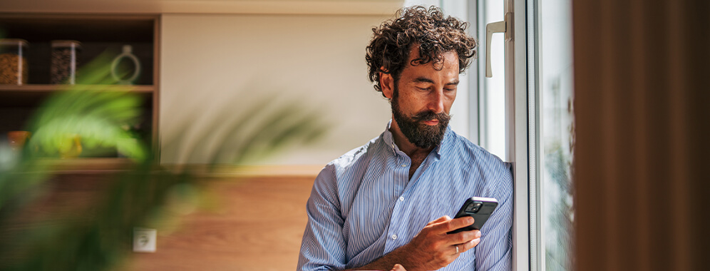 Ein Mann schaut auf sein Handy. 