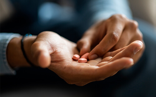 Ein Mann nimmt Tabletten ein.