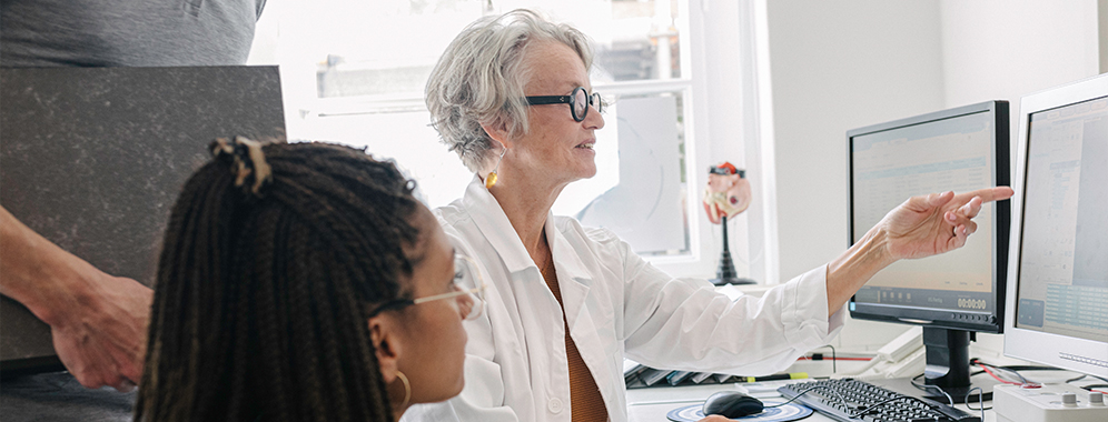 Eine Ärztin im Gespräch über Innovationen im Bereich MS-Forschung mit Kolleg*innen. 