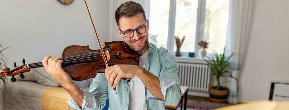 Ein Mann spielt Geige, wahrscheinlich arbeitet er als MS-Musiktherapeut.