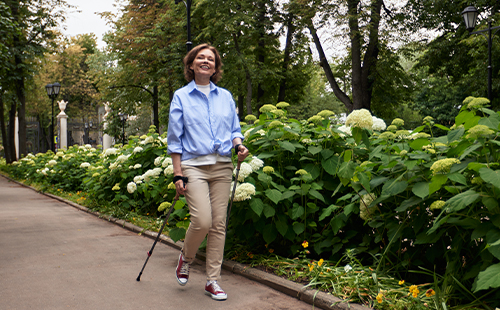 Eine Frau mit MS walkt im Park.