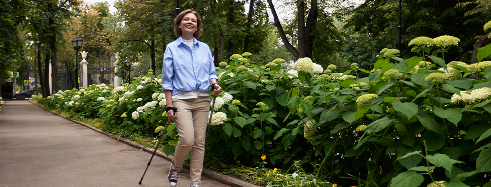 Eine Frau mit MS walkt in einem Park.