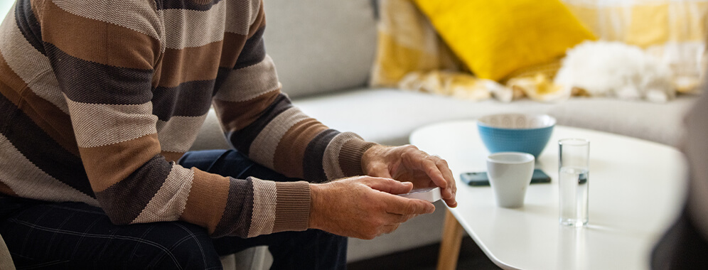 Man sieht den Oberkörper einer Person, die einen Test in der Hand hält und scheinbar die Ergebnisse abliest.