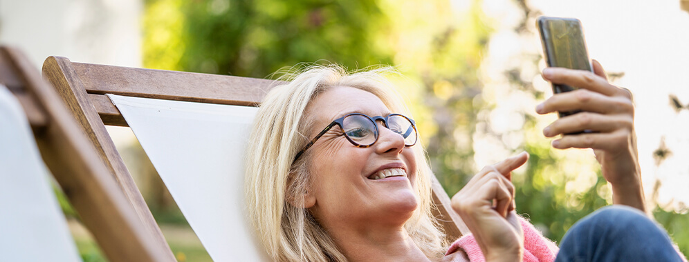 Eine Frau liest etwas auf dem Handy. 
