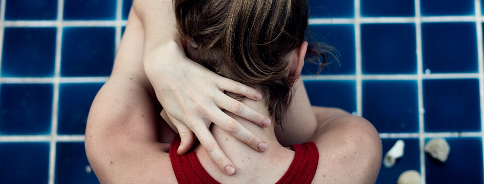 Eine Frau hält ihre Hand in den Nacken.