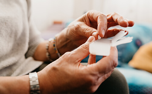 Eine Frau bestückt ihre Tablettenbox.