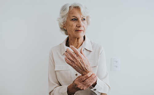 Eine Frau hält sich das Handgelenk.